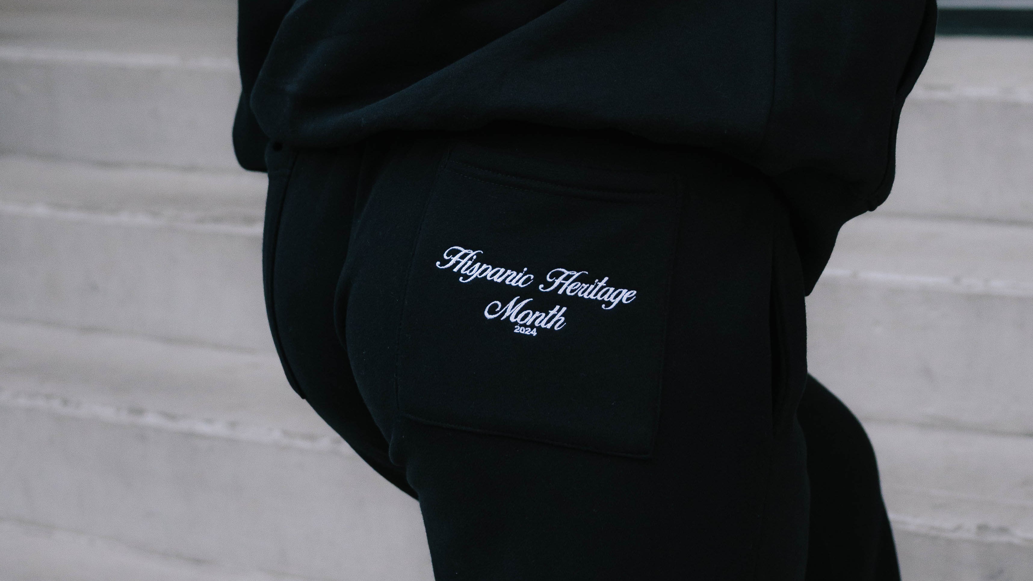 Black hoodie with 'Hispanic Heritage Month' text on a blurred background
